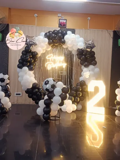 A football-themed second birthday with a black and white balloon ring and marquee number.