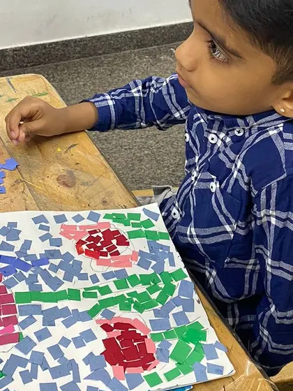 A student works diligently on his paper mosaic. This activity requires precision and planning, making it an excellent exercise for cognitive development and focus.