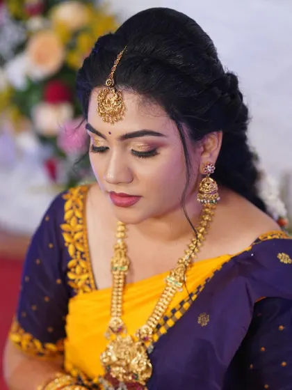 A close-up of Shruthi's makeup. The gold jewelry and soft eye makeup create a look that is timeless and beautiful.