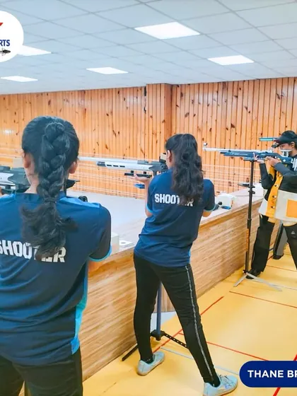 A view from behind the firing line at our Thane branch, showing young shooters practicing their standing rifle techniques. The "SHOOTER" text on their shirts reflects their dedication.