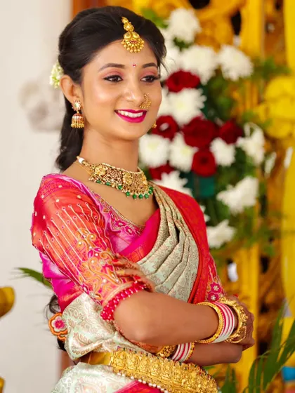 This bride is glowing for her pre-wedding function. The makeup is bright and festive, with a beautiful pink lip that matches her outfit.