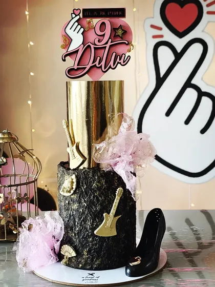 I made this Blackpink-themed cake for my daughter's birthday. It features a dramatic black textured tier and a metallic gold top tier, accented with guitars, a high heel, and the K-pop heart sign.