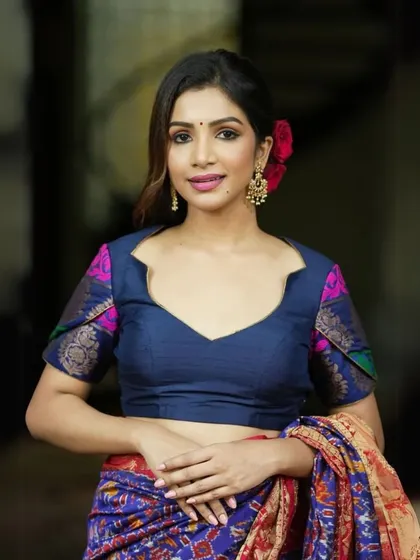 A classic navy blue blouse with contrasting printed fabric on the sleeves. The sweetheart neckline adds a touch of romance to this elegant piece.