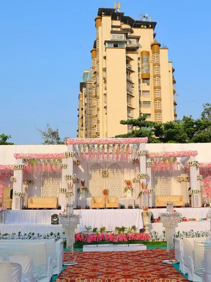 A daytime view of an outdoor wedding stage I decorated. The pink and white floral theme creates a classic and elegant look against the urban backdrop of Navi Mumbai.