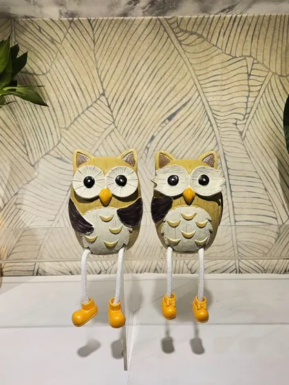 A pair of cute owls with dangling legs, perfect for sitting on the edge of a shelf or desk. Their playful design is sure to bring a smile.
