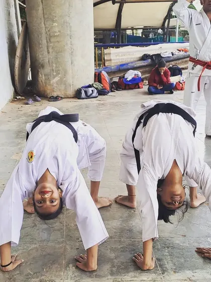 Flexibility and conditioning are non-negotiable. Two of our black belt students show their strength and control during the grading exam at the Malleshwaram dojo.