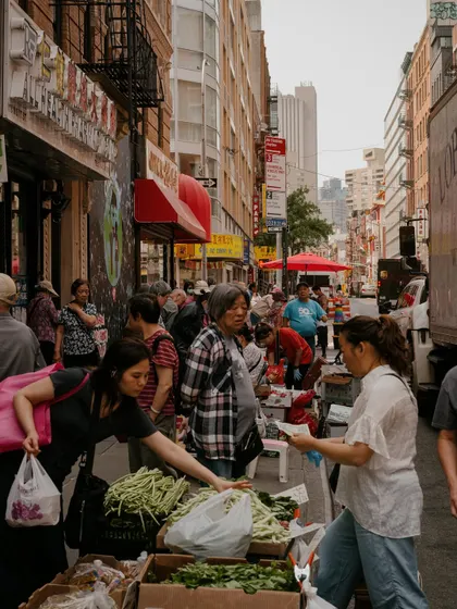 A busy street market scene in Chinatown, NYC. This type of street photography captures the authentic, daily life and energy of the city's diverse neighborhoods.