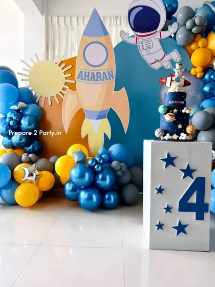 Blast off with my space-themed party decorations. These setups feature custom backdrops of the moon and sun, balloon garlands with chrome and planet balloons, and themed cake displays.