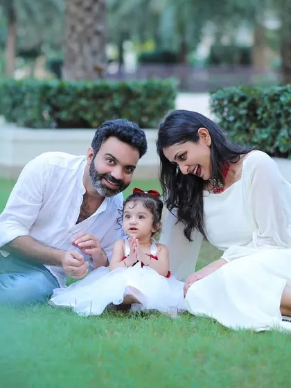 A family enjoying a beautiful day outdoors, sitting together on the grass. Our outdoor sessions are perfect for capturing natural interactions and candid smiles.