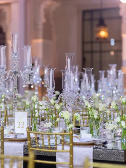 A simple yet elegant table setting from the Marrakech dinner, with white roses in small vases and crystal candelabras.