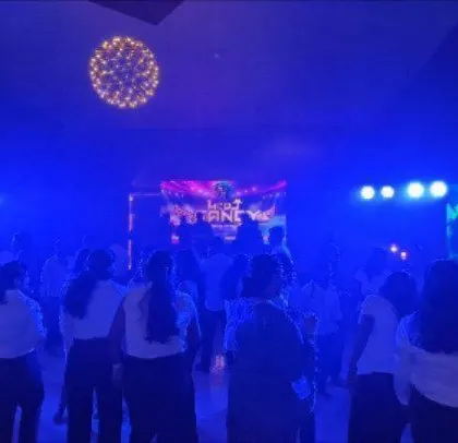 The dance floor is active at this corporate event, with blue lighting setting a cool tone.
