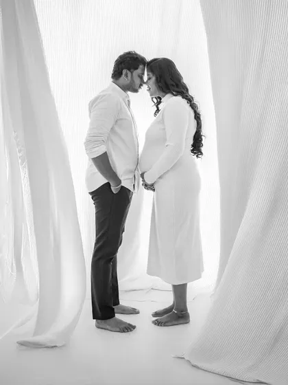 A classic black and white pose for expecting couples. This intimate forehead-to-forehead stance creates a powerful and timeless image of unity.