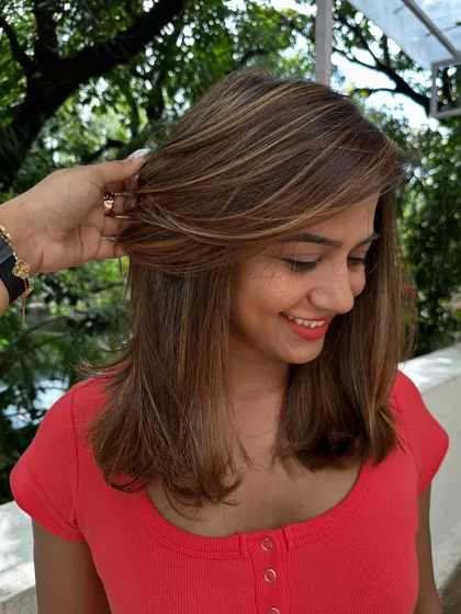 A happy client showing off her new party-ready hair.