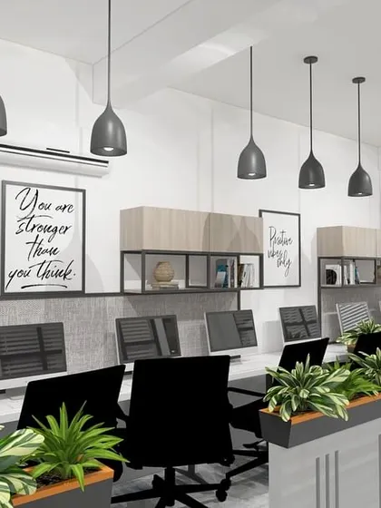 An open-plan office with workstations separated by planters. This biophilic design approach enhances the work environment by bringing nature indoors.