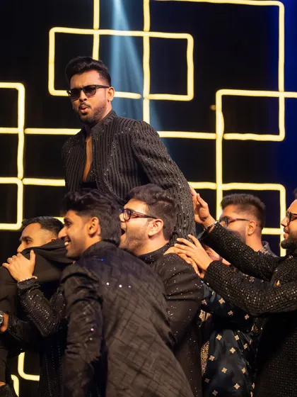 The groom's squad lifting him up during their high-energy performance. Sangeet nights are all about these unforgettable moments.