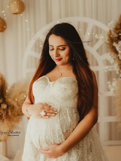 A close-up to capture the serene expression and the beautiful details of the lace gown. The soft lighting and warm tones make this a very gentle and loving portrait.