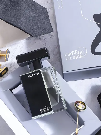 An elegant flatlay showing the 'Maverick' perfume in its gift box, surrounded by accessories. This composition highlights its value as a premium gift for men.
