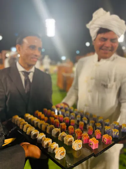 Waitstaff presenting a large platter of colorful, assorted sushi rolls to guests, an example of my attentive pass-around service.