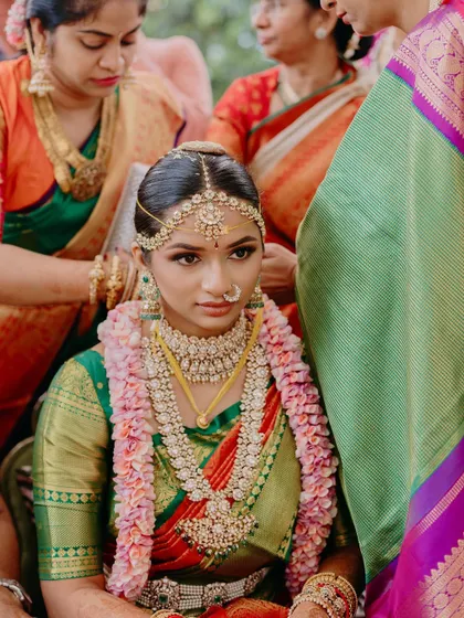 A special moment from a Mahuratham ceremony. The focus is on the bride's serene expression, enhanced by traditional makeup that highlights her eyes and gives her a divine glow.