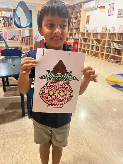 A proud boy showing off his beautifully decorated Kalash painting. We explore various cultural symbols through our art and craft activities.