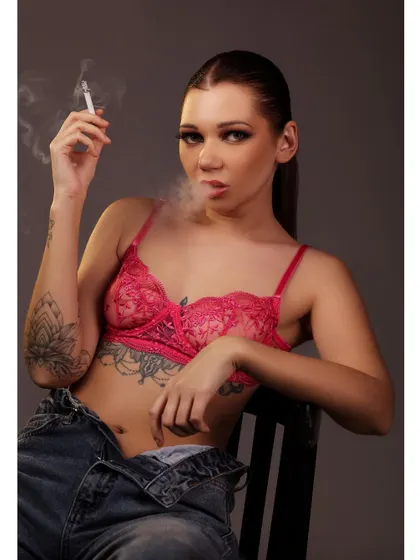 Another shot from the same series, capturing the smoke as it curls from the cigarette. The lighting is focused and dramatic, adding to the moody and defiant atmosphere.