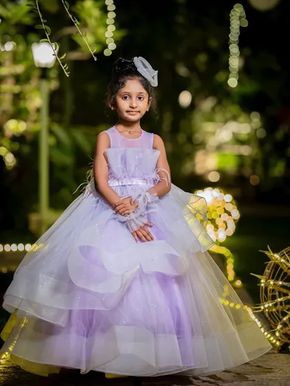A beautiful portrait of a young birthday girl in her party dress, captured in an outdoor setting with magical lighting.