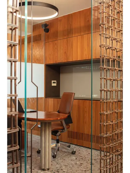 A closer look at the rebar screen partition, showing how the grid-like structure filters light and views while maintaining a sense of openness in the conference room.