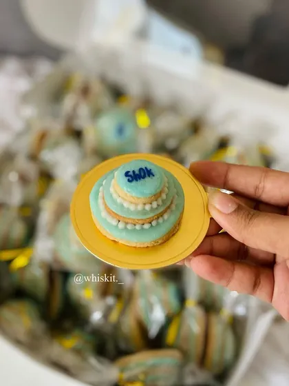 A close-up of my custom three-tier wedding cake cookie, individually wrapped and ready to be given as a wedding favor.
