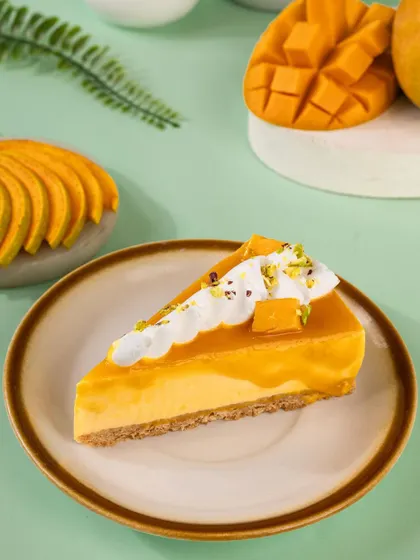 A perfect slice of the mango cheesecake, showing its creamy texture and crumbly crust.