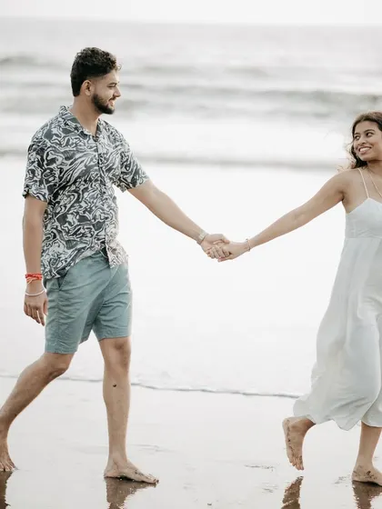A happy, candid walk on the beach. This photo shows the couple's natural interaction and joy.