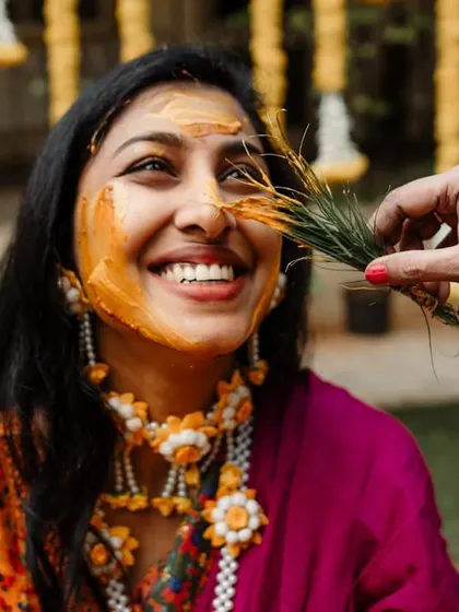 A happy bride during her Haldi ceremony, with a playful touch from a friend. These are the moments that truly show the love and joy of a wedding.