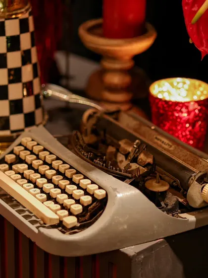 A close-up of a vintage typewriter, a thoughtful detail that adds a layer of narrative and old-world charm to a modern cocktail party setting.