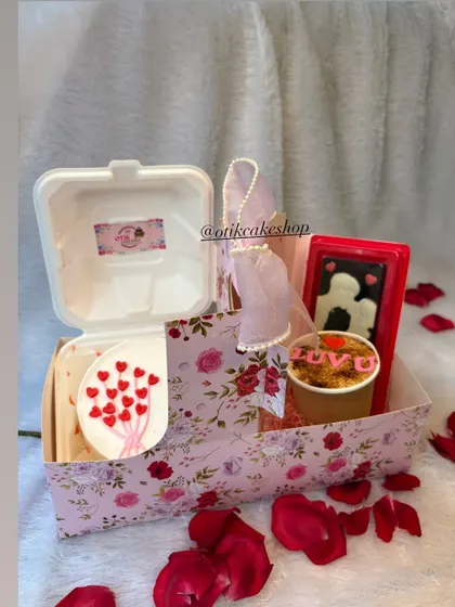 A complete Valentine's gift set in a floral box, featuring a bento cake, a cake tub, and a chocolate bar card, surrounded by rose petals.