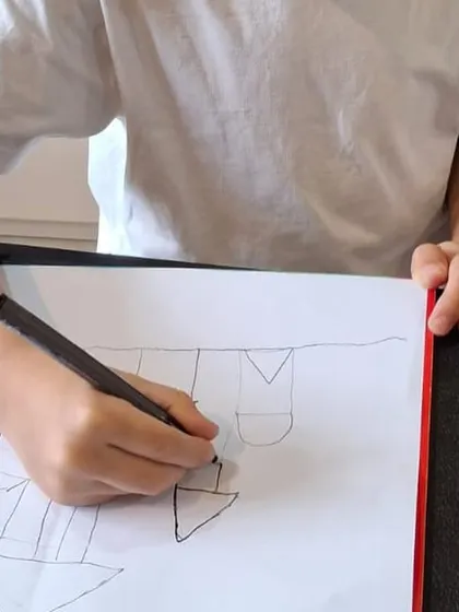 This image shows the initial sketching phase of a castle drawing. We teach children to build complex structures using simple, manageable shapes, which is a core part of our method.