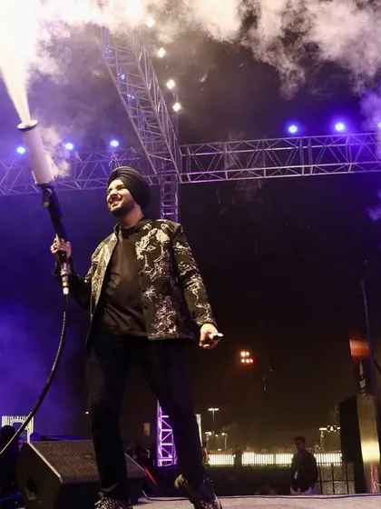 A full-body shot of Gurdeep Mehndi commanding the stage with a CO2 cannon. This image demonstrates our ability to integrate high-impact special effects safely and effectively into a live performance.