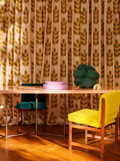 A dining space featuring curtains made from the embroidered 'I'm Not Afraid' fabric by Élitis. The bold, 70s-inspired pattern and vibrant colors infuse the room with a dynamic and joyful rhythm.