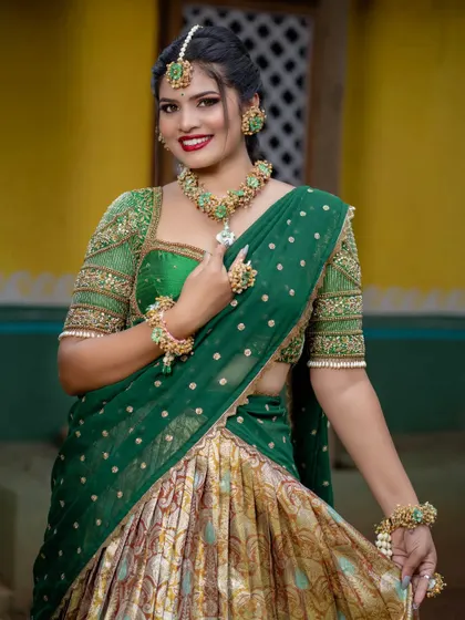 A full view of the green half-saree look, perfect for pre-wedding celebrations. The combination of the outfit, makeup, and floral jewelry creates a fresh and festive vibe.
