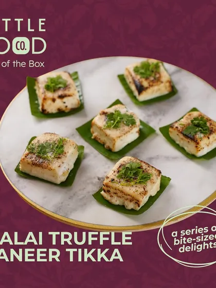 Our Malai Truffle Paneer Tikka, a perfect example of our "Out of the Box" delivery delights. These creamy, truffle-infused paneer bites are grilled to perfection and served on banana leaves for an authentic touch.