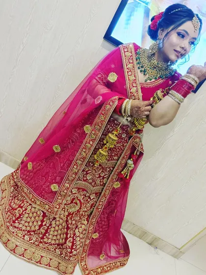 A beautiful bride in a classic red and gold embroidered lehenga. The delicate net dupatta and matching jewellery complete this perfect wedding day look, all available for rent.