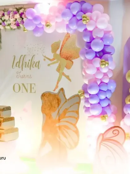 A beautiful butterfly-themed first birthday setup with purple and gold accents.