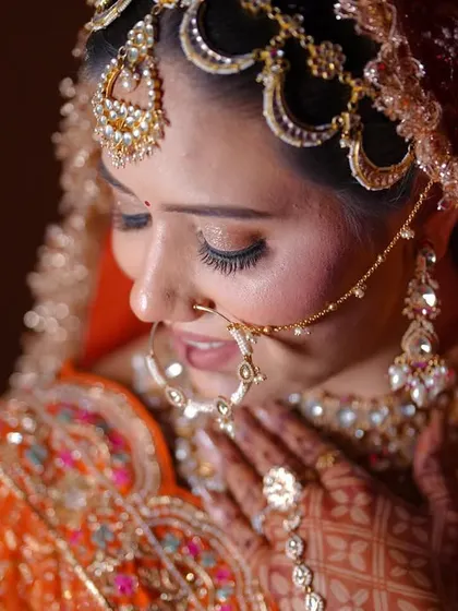 A delicate close-up portrait of the bride, focusing on her gentle expression and stunning matha patti.