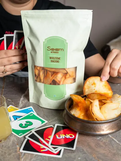 Plot twist: you can win at UNO and snacks. My Masala Ratalu Chips are shown as the perfect gaming partner, adding spice to a fun game night.
