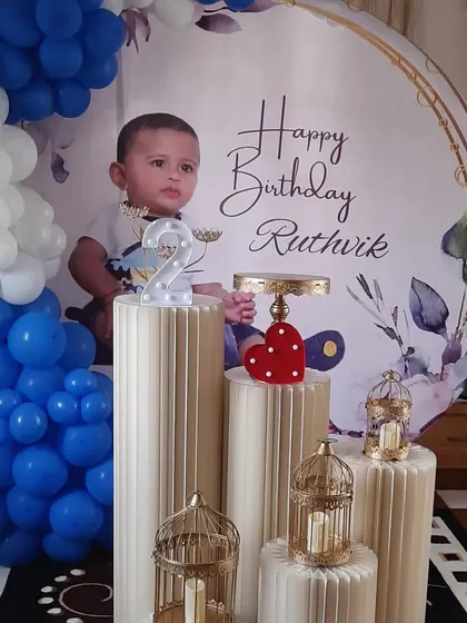 A Boss Baby themed second birthday party with a custom circular backdrop. The blue and white balloon arch complements the theme perfectly.
