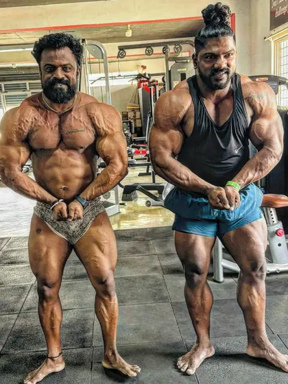Two generations of muscle. Posing alongside a fellow massive bodybuilder, showcasing different structures but the same dedication to the sport.