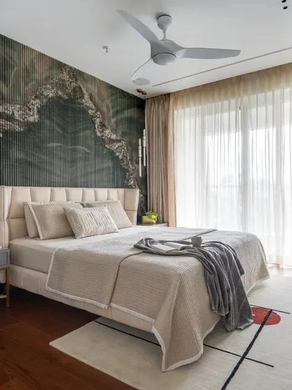 In this master bedroom, I wanted to create a dramatic yet calming focal point. I achieved this with a custom back wall featuring a striking green marble pattern set against handmade flutes. Paired with rich wooden flooring and soft, layered textiles, the room becomes a personal sanctuary that feels both luxurious and deeply restorative.