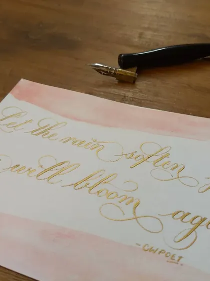A different angle of the "Let the rain soften you" piece, showing how the iridescent gold ink shines from the side.