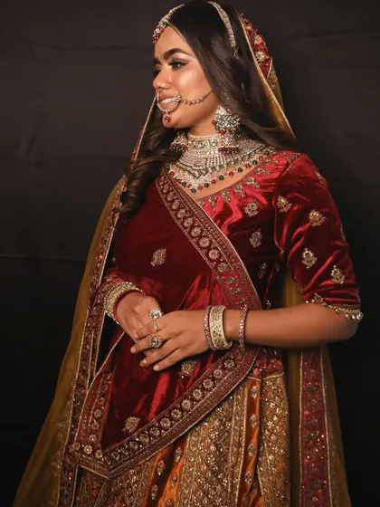 A side profile showcasing the detailed embroidery on the velvet blouse and the beautiful kalire. This is a complete bridal look available for rent.