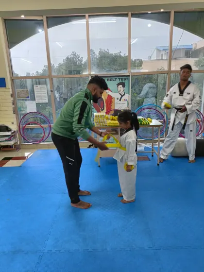 Tying a yellow belt for a young girl.