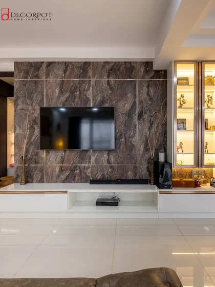 A full view of the luxurious TV unit from image 31. The combination of the dark marble, white console, and lit display cabinet makes for a truly spectacular living room feature.