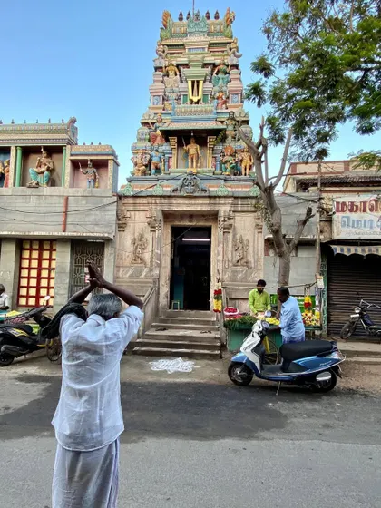 A street scene in front of a temple, capturing a moment of daily life. Public architecture must provide a backdrop for these unscripted interactions.